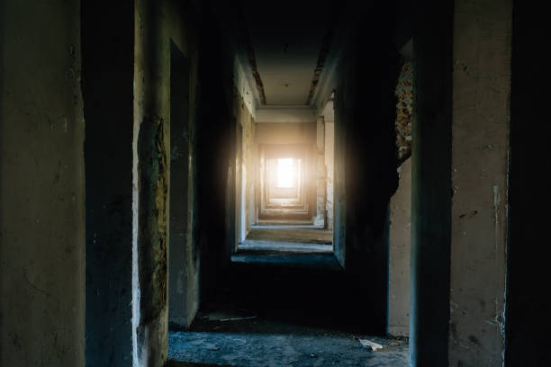 istock Abandoned corridor with sunlight streaming through window illuminating old walls creating mysterious atmosphere ideal for horror and urban exploration concepts 2204852394
