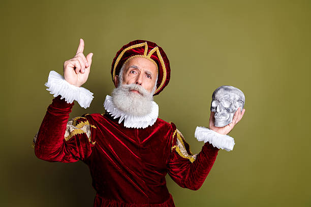 istock Mature Man Dressed in a Renaissance Costume Posing Against a Solid Khaki Background 2204854441