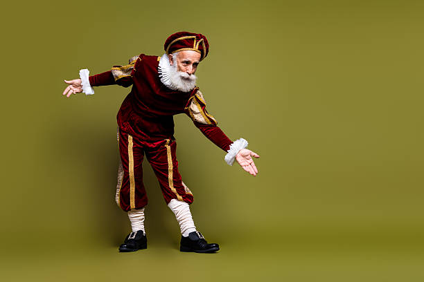 istock Senior man dressed as medieval nobleman posing against a khaki backdrop, showcasing vintage and royal renaissance style 2204854459