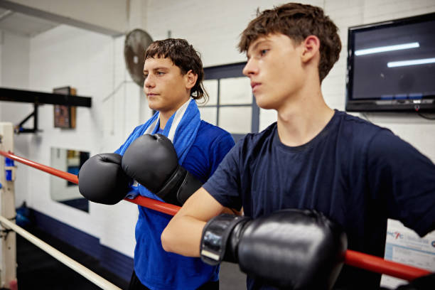 istock Young male sparring partners resting outside the ropes 2204854979