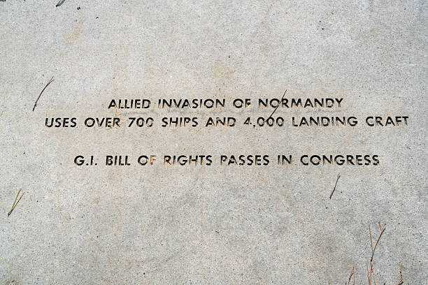 Young boy sitting on WWII memorial above the words \