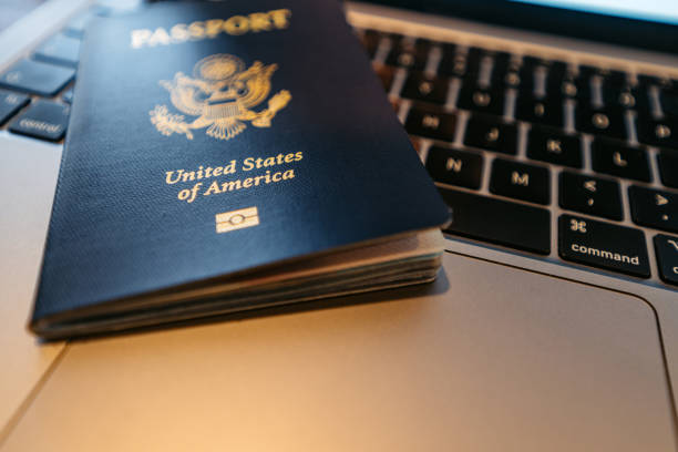 A USA passport on a laptop indoors.