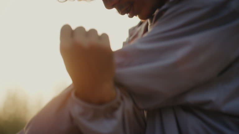 Close-up shot of a man shaking his hands to warm up before running