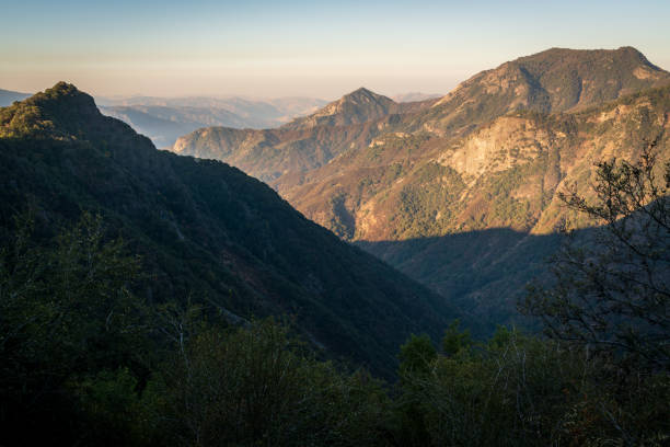 A truly iconic sunset overlooking a breathtaking view in Southern California's Sequoia National Park. The sky is glowing with a rich and vibrant red to orange to blue gradient light and the various mountain ranges disappear into the haze in the distance. No clouds. No people. No distractions.