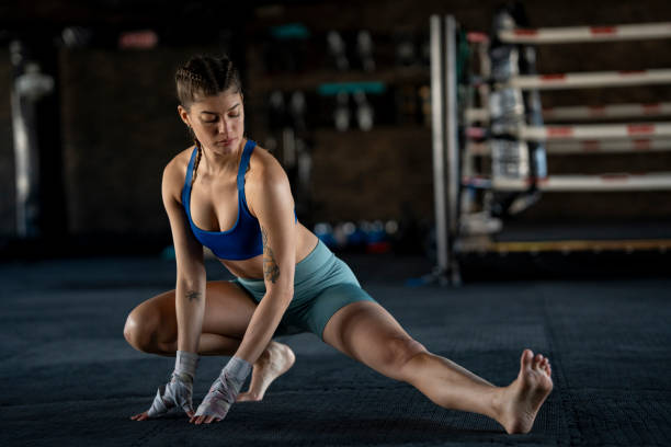 istock Female boxer stretching legs in gym after training 2204858123