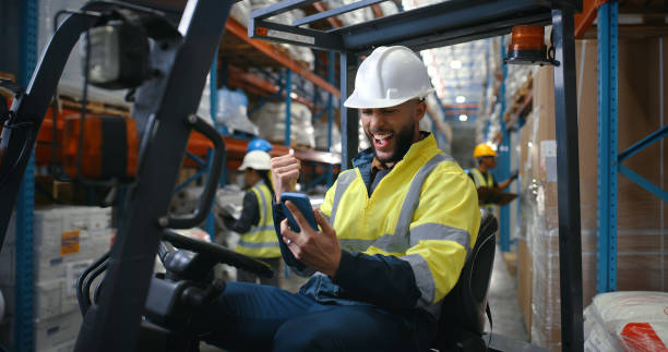 istock Driver, warehouse and man with phone, forklift or smile for loading on dock with good news, bonus or success. Winning, excited factory worker or shipping inventory with gambling prize or delivery 2204864091