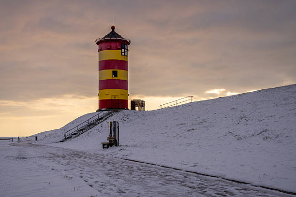 Pilsum, Germany - February 13, 2025: Lighthouse of Pilsum during sunset on February 13, 2025 in East Frisia, Germany