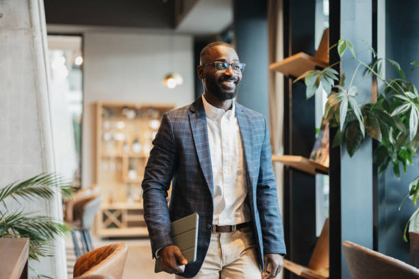 istock Stylish man walking with laptop in modern setting 2204864832