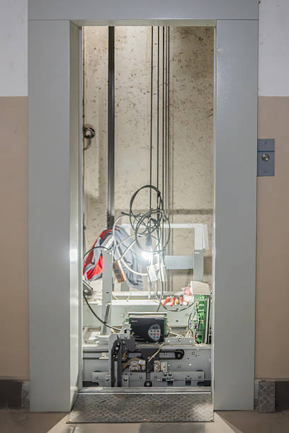 istock Elevator doors open in case of breakdown, vertical photo. Elevator repair and maintenance, emergency situation. The Machinery Room features modern components, along with essential cables and equipment 2204866192