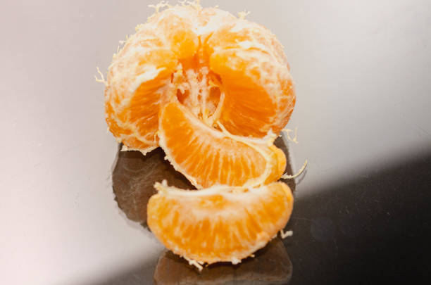 Peeled tangerine fruit arranged in rows and columns. Directly above view.