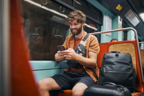 istock Phone, typing and man on bus at night on vacation with online hotel checkin on mobile app. Cellphone, dark and male person reading tourism blog for tips, advice or rules for public transport travel. 2204867232