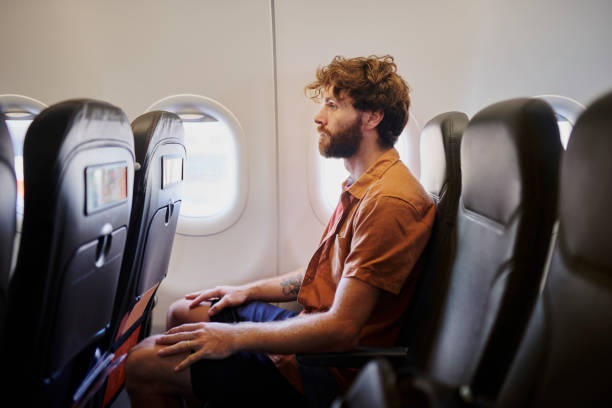 istock Man, airplane and thinking by window on flight with reflection, profile or perspective for career decision. Person, immigration and travel on jet plane, insight and transport for international trip 2204867239