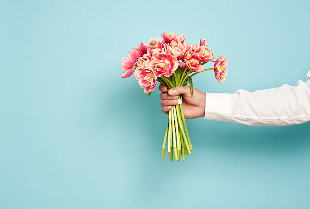 istock Romantic man presents a bouquet of tulips 2204868822