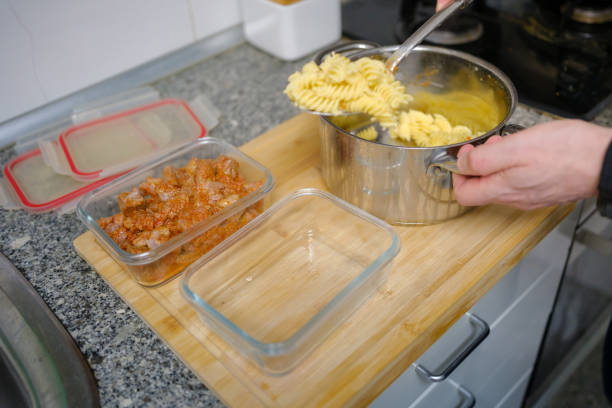 istock Chef serving marinated pork into glass container in kitchen 2204869730