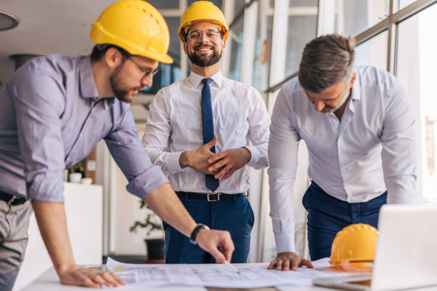 istock Architects and engineers studying blueprint in office meeting 2204869909