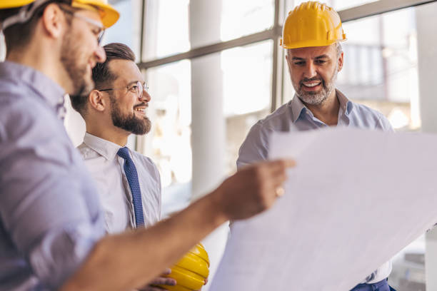 istock Architects and engineers discussing blueprint plans in office 2204871516