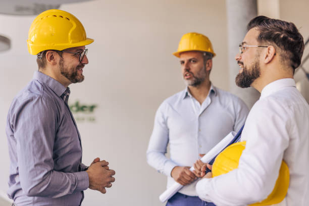 istock Engineers wearing hardhats discussing a project in the office 2204871997