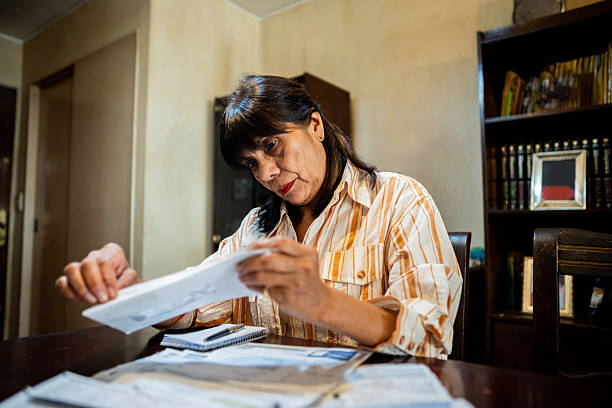 istock Senior woman looking home bills at home 2204876673