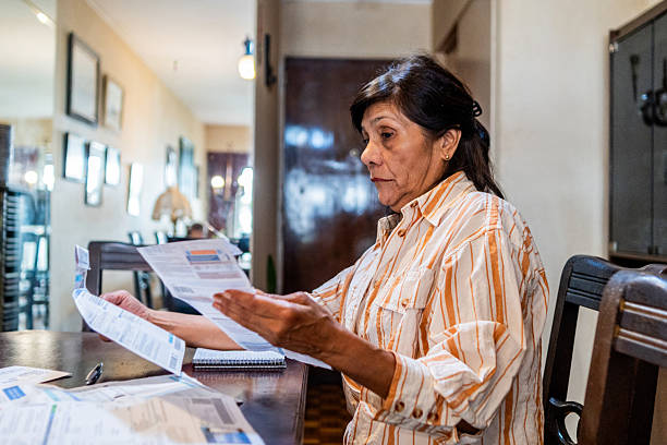 istock Senior woman looking home bills at home 2204876895