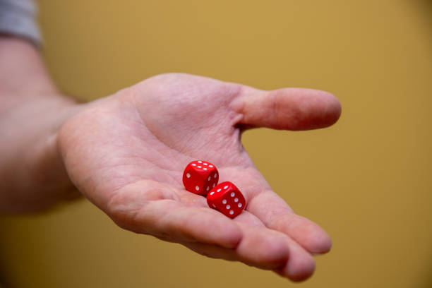 istock close up of human hand holding red dice 2204877015