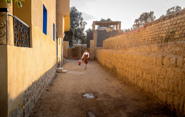 Faiyum, Egypt. March 7, 2025. A young man walking with his cleaning bucket in Faiyum Egypt