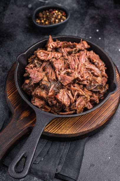 istock Traditional barbecue pulled beef, Slow cooked meat cooked in a smoker. black background. top view 2204879125