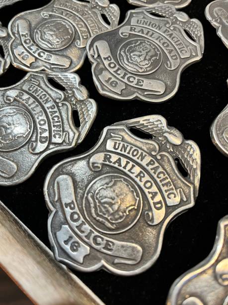 Multiple Union Pacific Railroad police badges, crafted from metal, are neatly arranged on a dark surface, showcasing their intricate details and historical significance