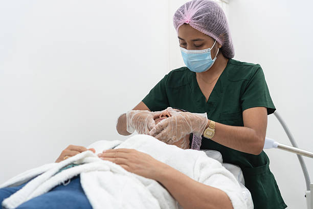 istock Beautician examining patient's face in clinic 2204882884