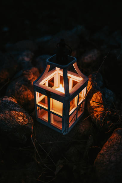 istock Glowing Lantern with a Candle Among Rocks at Night 2204883411