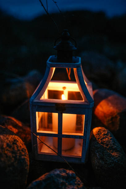 istock Glowing Lantern with a Candle Among Rocks at Night 2204883442