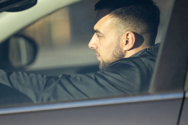 istock A handsome man sits focused behind the wheel, driving a car 2204885576