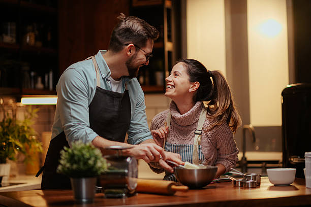 Smiling couple enjoying cooking together in kitchen