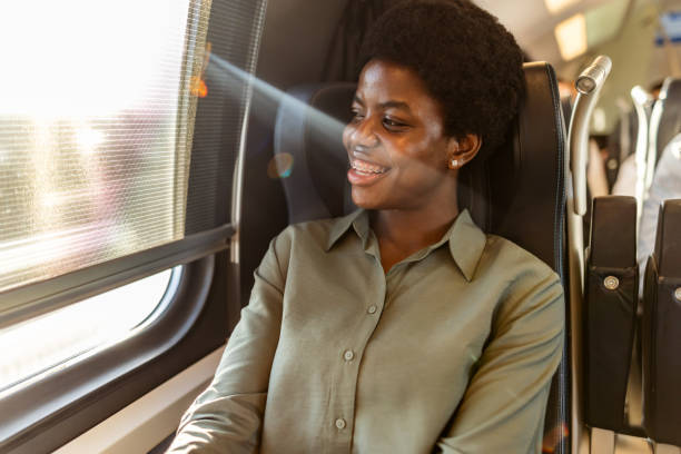 istock Smiling Woman Enjoying a Train Journey With Sunlight Streaming In 2204892526