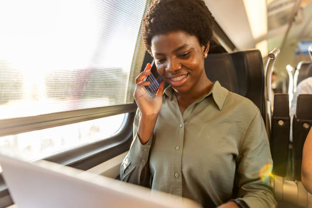 istock Businesswoman on a Train Having a Conversation and Using a Laptop 2204892591