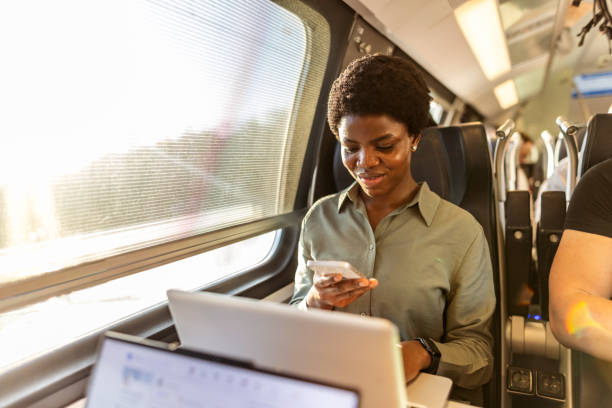 Woman Using Smartphone and Laptop While Traveling on a Train