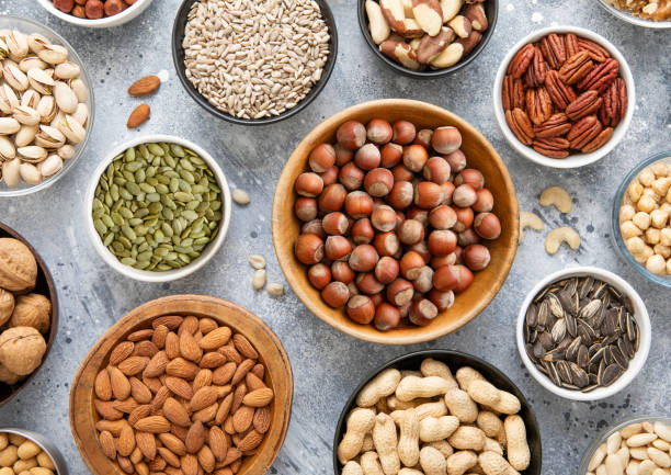 istock Mixed healthy nuts and seeds in various bowls on kitchen table.Peanut,hazelnut,walnut,almonds,pistachio,sunflower,pumpkin,chia and cashew.Top view. 2204893293