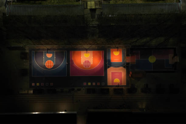 Aerial view of colorfull outdoor illuminated basketball courts and playgrounds at night in Aarhus, Denmark