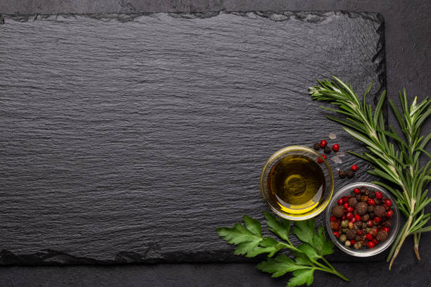 istock black textured background with slate board and spices, olive oil and herbs 2204895537