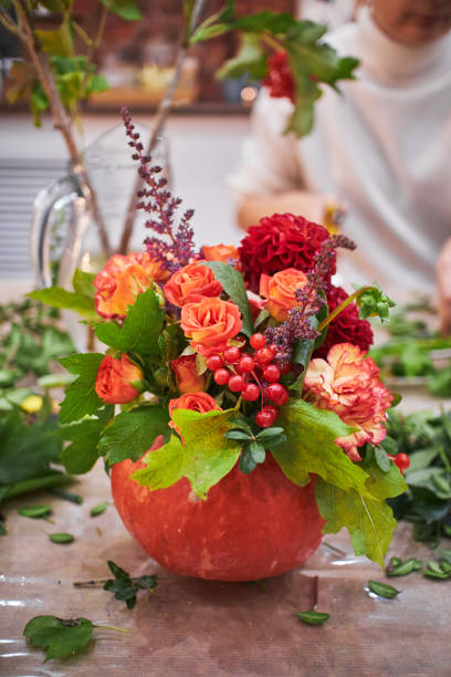 istock Master class on making bouquets. Autumn bouquet in a pumpkin. Flower arrangements, creating beautiful bouquets with your own hands 2204896873