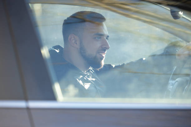 istock A handsome man sits focused behind the wheel, driving a car 2204897807