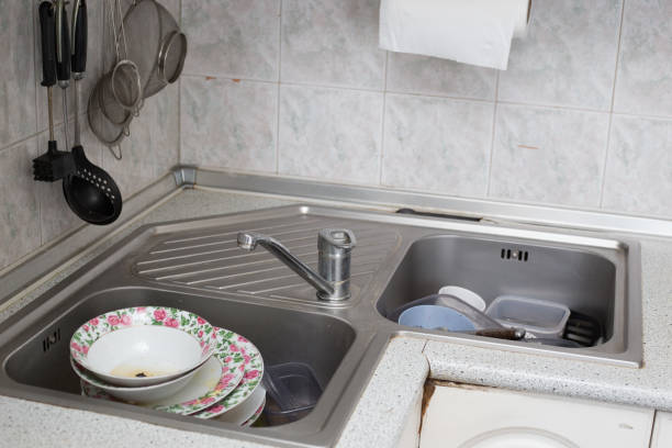 istock Dishwashing: Hand with pink sponge washing dishes in kitchen sink 2204898118