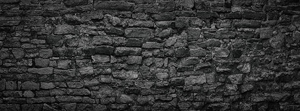 istock black stone wall an old castle, dark background of slate bricks 2204899061