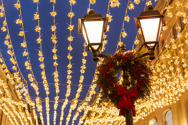 istock Street lamp adorned with christmas wreath and string lights 2204900916