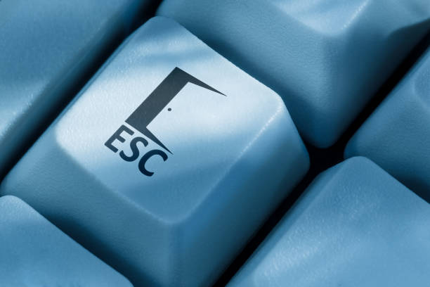 Close-up of a blue keyboard Escape (ESC) key featuring an open door symbol, symbolizing freedom, exit, or escape concept.