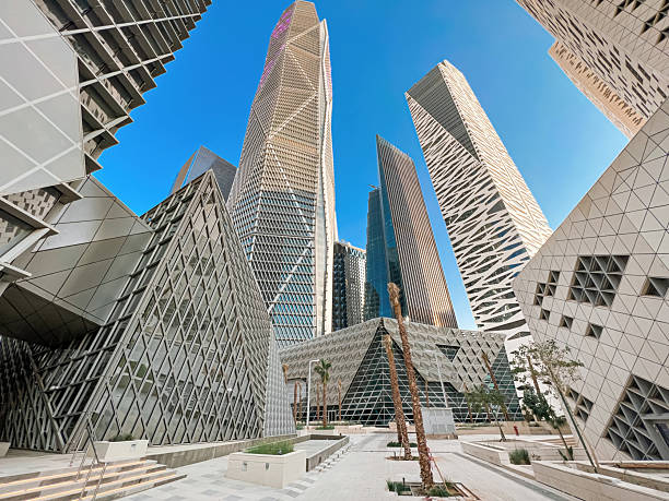 Modern Geometric Architecture at King Abdullah Financial District. A striking geometric architectural design in the heart of King Abdullah Financial District (KAFD), Riyadh, Saudi Arabia. The futuristic facade, made of angular, interwoven shapes, showcases contemporary innovation while reflecting the city's ambition as a global financial hub. The combination of glass, stone, and sharp lines adds to the building's bold aesthetic. High-quality photo