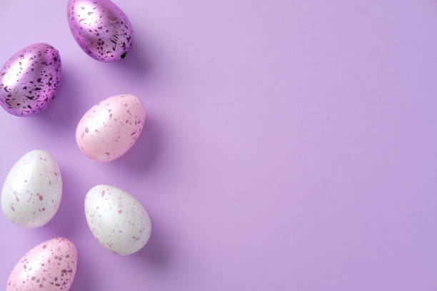 istock Colorful speckled Easter eggs on a pastel purple background. Top view minimalist Easter background. 2204908918