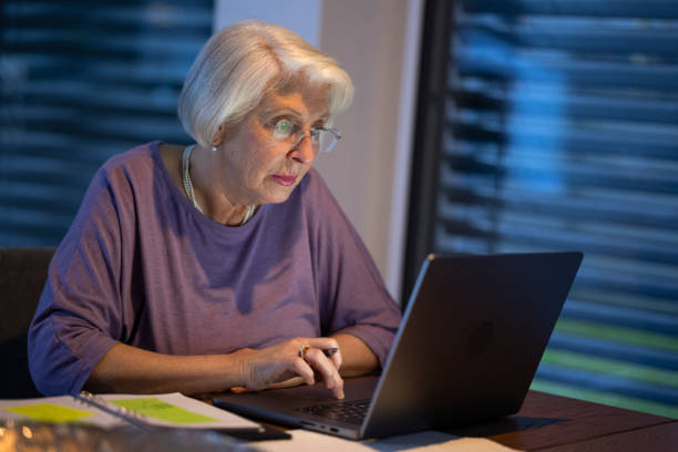 istock Senior Woman Working At Night On Laptop 2204909099