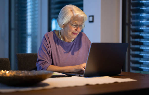 istock Senior Woman Working At Night On Laptop 2204909105