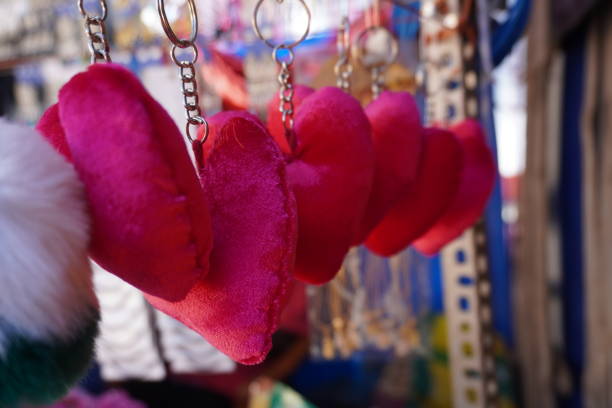 Several heart-shaped keychains, likely made of fabric, hanging from a display