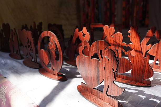 istock Several wooden cutout crafts, likely depicting human figures and hearts, arranged on a surface, possibly for display or sale 2204912137